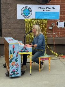Man playing piano and singing into a microphone
