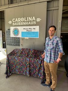 man preparing to unveil painted piano