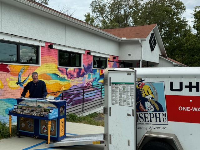 Man moving piano toward a UHaul trailer