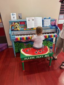 Little girl plays painted piano