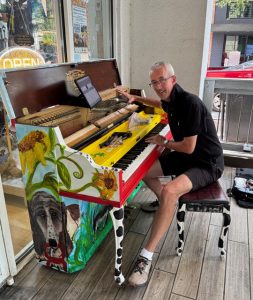 Man tuning a painted piano