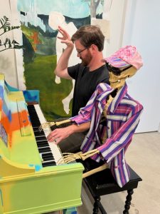 Man and Skeleton decoration play duet at piano